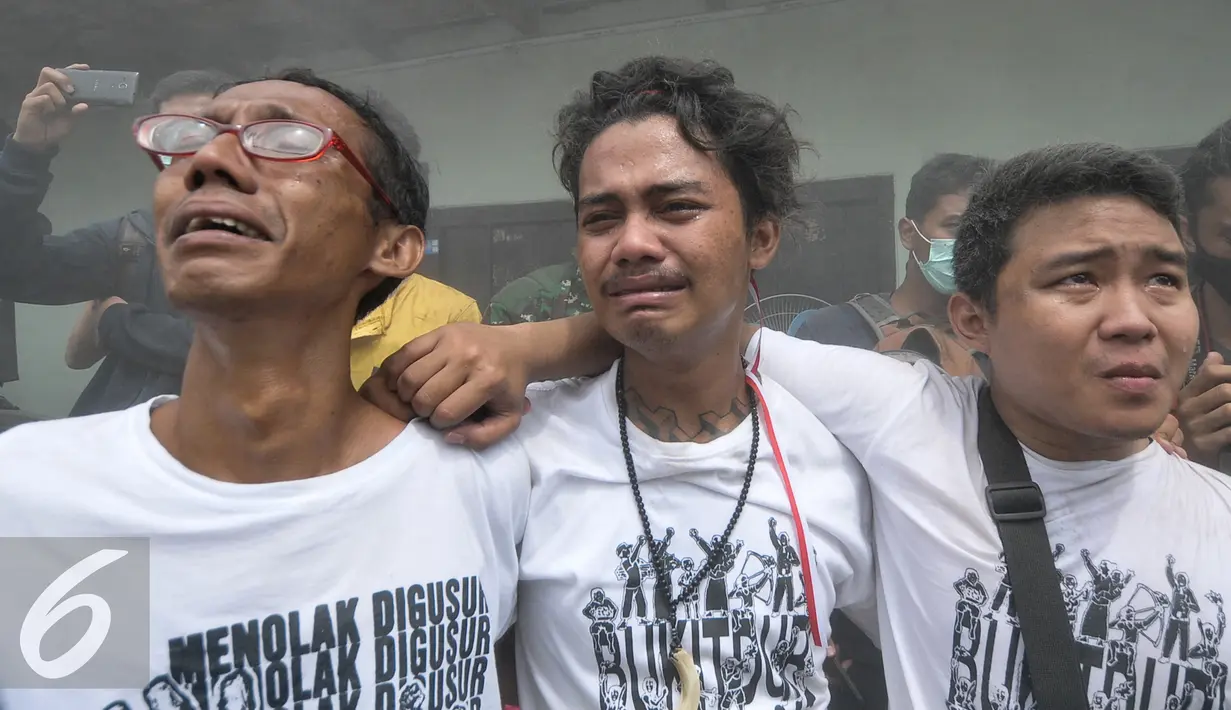 Sejumlah warga menangis saat Sanggar Saung Merdeka Ciliwung Bukit Duri digusur, Jakarta, Rabu (28/9). Padahal saat kampanye, Jokowi-Ahok berjanji tidak akan menggusur kawasan Ciliwung melainkan akan membangun kampung deret. (Liputan6.com/Yoppy Renato)