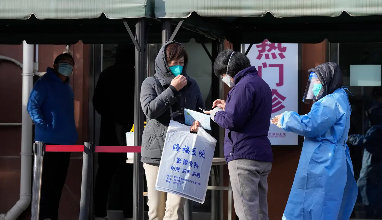 Warga mengobrol di luar klinik di Beijing, China, Kamis (15/12/2022). Seminggu setelah China melonggarkan beberapa tindakan pengendalian COVID-19 yang paling ketat di dunia, ketidakpastian masih ada mengenai arah pandemi di negara dengan jumlah penduduk terpadat di dunia tersebut. (AP Photo/Ng Han Guan)