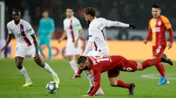 Pemain Galatasaray Omer Bayram terjatuh saat berebut bola dengan Pemain Paris Saint-Germain Neymar saat pertandingan Grup A Liga Champions di Stadion Parc des Princes, Paris, Prancis, Rabu (11/12/2019). PSG menang 5-0. (AP Photo/Christophe Ena)