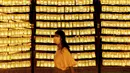 Pengunjung berjalan melewati lentera kertas saat Festival Mitama di Kuil Yasukuni, Tokyo, Jepang, Rabu (14/7/2021). Festival Mitama dirayakan sejak 1947 untuk menghormati jiwa para arwah yang diabadikan serta tentara yang gugur dari perang Jepang di masa lalu. (BEHROUZ MEHRI/AFP)