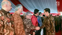 Presiden Jokowi menyalami tamu saat HPN 2018 di Padang, Sumatera Barat, Jumat (9/2). Jokowi memerintahkan Menteri PUPR Basuki Hadimuljono untuk menyelesaikan revitalisasi seribu rumah gadang pada tahun ini juga. (Liputan6.com/Pool/Biro Setpres)