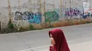 Warga berjalan di sekitar dinding Jalan Tol Depok-Antasari (Desari), Ciganjur, Jakarta Selatan, Rabu (24/10). Tol Desari diresmikan oleh Presiden Joko Widodo pada 27 September 2018. (Liputan6.com/Immanuel Antonius)