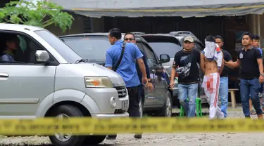 Petugas polisi mengawal pelaku teror bom bunuh diri di Gereja Santo Yosep Medan, Sumut, Minggu (28/8). Pelaku berhasil diamankan, lantaran bom yang dibawa di dalam ransel dan hendak diledakkan saat Misa, justru gagal meledak dan melukai pelaku. (AFP/STR)