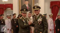 Panglima TNI Jenderal Gatot Nurmantyo bersalam komando dengan KSAD yang baru Letjen TNI Mulyono usai dilantik di Istana Negara, Jakarta, Rabu (15/7/2015). Letjen Mulyonos sebelumnya menjabat sebagai Pangkostrad. (Liputan6.com/Faizal Fanani)