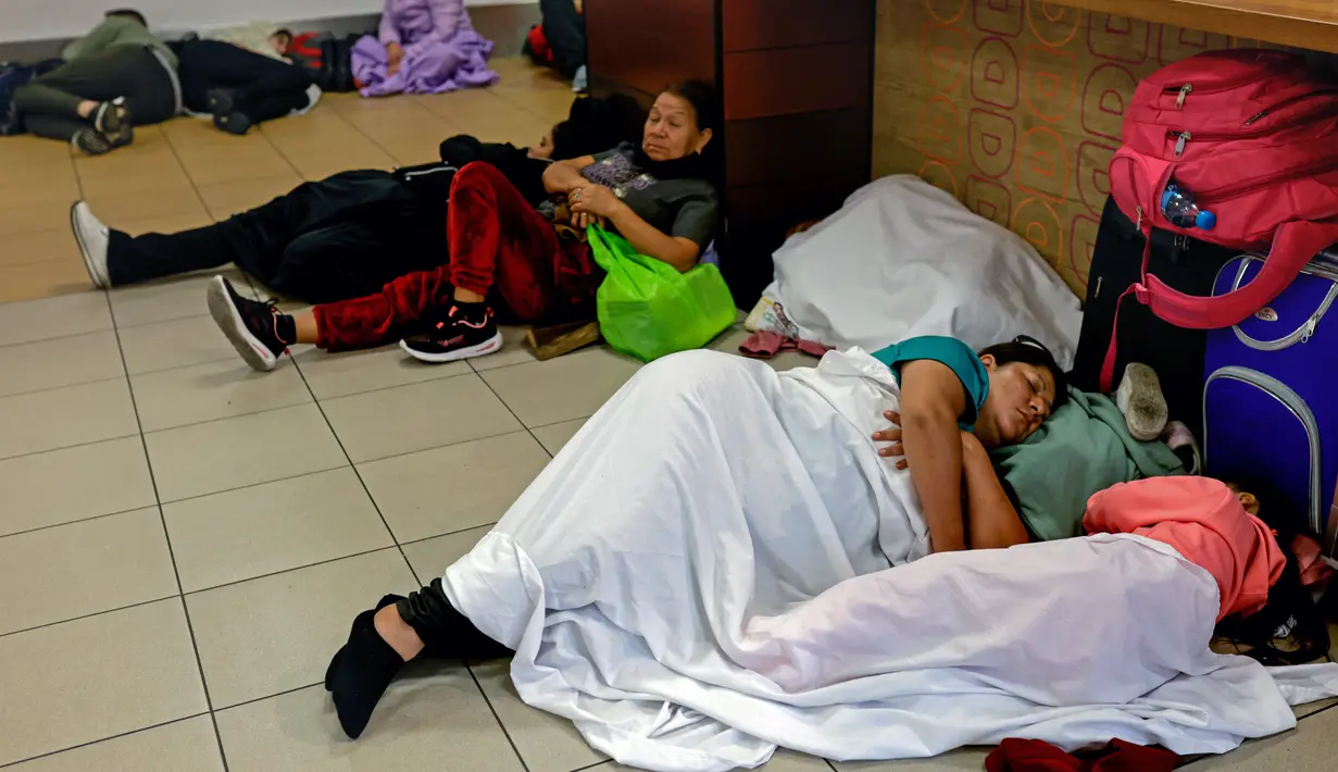Sementara yang lain tidur di lorong atau kursi bandara menunggu informasi. (Juan Carlos CISNEROS / AFP)