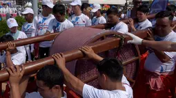 Warga Kamboja membentangkan syal krama untuk memecahkan rekor Guinness sebagai syal tenun terpanjang dunia di Phnom Penh, Minggu (1/7). Syal dengan panjang 1.149,8 meter dan lebar 88 cm tersebut dibentangkan di luar Istana Kerajaan. (AFP/TANG CHHIN Sothy)