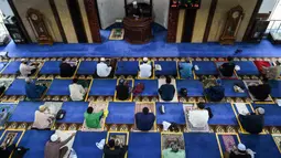Umat muslim menjaga jarak saat salat Jumat usai pencabutan pembatasan Covid-19 di Masjid Al-Istighfar, Singapura, Jumat (26/6/2020). Masjid-masjid di Singapura telah diizinkan menggelar salat berjamaah, seiring memasuki pekan kedua dari Tahap Dua pembukaan kembali di negara itu. (Roslan RAHMAN/AFP)