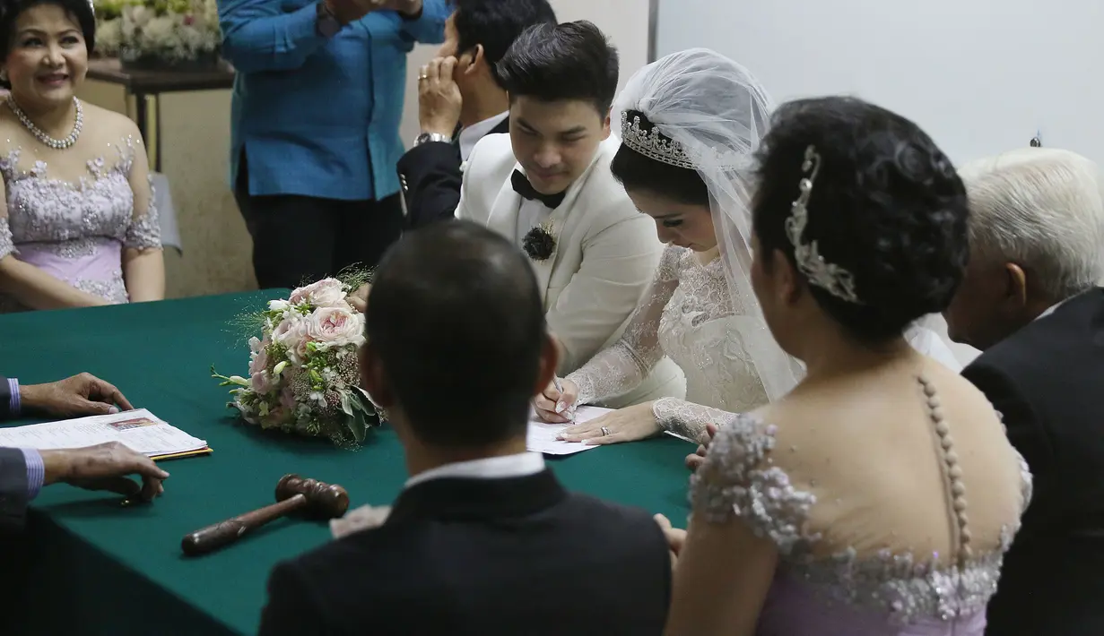 Chelsea Olivia menulis data dirinya saat acara pemberkatan pernikahan, Jakarta, Kamis (1/10/2015). Chelsea dan Glenn tampak serasi dengan busana pengantin nuansa putih yang dikenakannya (Liputan6.com/Herman Zakharia)