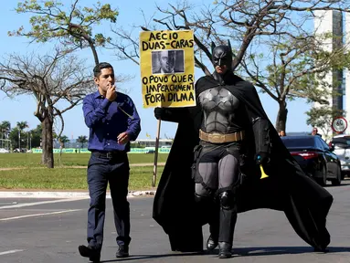 Seorang aktivis mengenakan kostum superhero Batman turun ke jalan memprotes Presiden Brasil Dilma Rousseff di Gedung Kongres Nasional, Brasil (27/5/2015). Aktivis ini menuntut keadilan terkait kebijakan pemotongan anggaran. (REUTERS/Adriano Machado)