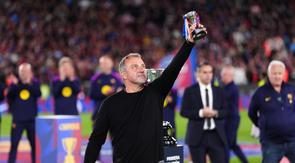 Pelatih kepala Barcelona, Hansi Flick, mengangkat trofinya ke langit sambil merayakan kemenangan setelah mengalahkan Real Madrid 2-0 untuk menjuarai liga sepak bola Spanyol (La Liga) dengan tiga pertandingan tersisa, di Barcelona, Spanyol, Minggu, 10 Mei 2026. (AP Photo/Joan Mateu Parra)