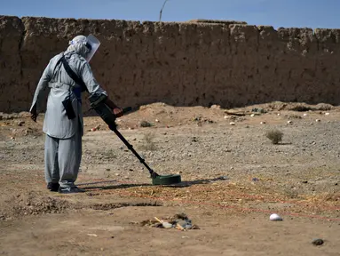 Organisasi penjinak ranjau HALO Trust memindai tanah untuk mencari ranjau dengan detektor logam di desa Nad-e-Ali, provinsi Helmand pada 9 November 2021. Sekitar 41.000 warga sipil Afghanistan terbunuh atau terluka oleh ranjau darat dan persenjataan yang tidak meledak sejak 1988. (Javed TANVEER/AFP)