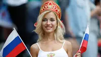 Suporter wanita tersenyum sambil memegang bendera Rusia sebelum pertandingan grup A Piala Dunia 2018 antara Rusia dan Arab Saudi di stadion Luzhniki di Moskow, (14/6). Dalam pertandingan ini, Rusia menang 5-0 atas Arab Saudi. (AP Photo/Antonio Calanni)
