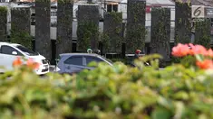 Kendaraan melintas di depan taman vertikal kawasan Tugu Tani, Jakarta Pusat, Senin (17/7). Tanaman hias yang dulu yang berjajar indah dan asri, kini banyak yang mati sehingga mengganggu keindahan kota. (Liputan6.com/Immanuel Antonius)
