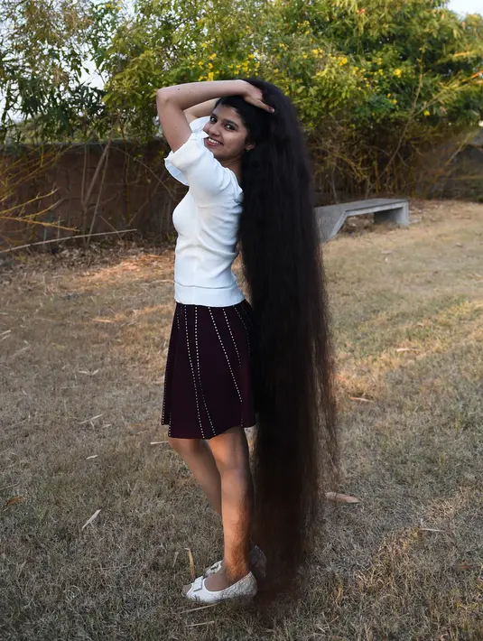 Gadis asal India, Nilanshi Patel (17) berpose untuk foto di kota Modasa, Ahmedabad, Minggu (19/1/2020). Pada 2018, Patel mencatatkan dirinya dalam daftar Guinness World Records pada kategori yang sama, yaitu pemilik rambut terpanjang di dunia dengan panjang hingga 170,5 cm. (SAM PANTHAKY/AFP)