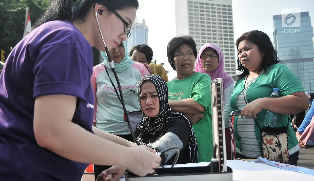 Dokter yang tergabung dalam Ikatan Ahli Patologi Indonesia (IAPI) memeriksa tensi warga saat Hari Bebas Kendaraan Bermotor (HBKB) atau car free day di kawasan Bundaran HI, Jakarta, Minggu (18/11). (Merdeka.com/Iqbal S. Nugroho)
