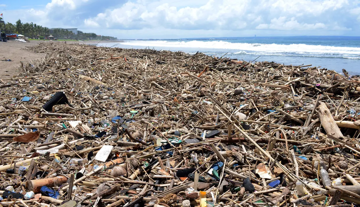 Tumpukan puing dan sampah memenuhi pantai setelah tersapu badai lepas pantai di Batu Belig di Kabupaten Badung, Bali (14/12/2021). Tumpukan sampah plastik dan puing tersebut mencemari bibir pantai. (AFP/Sony Tumbelaka)