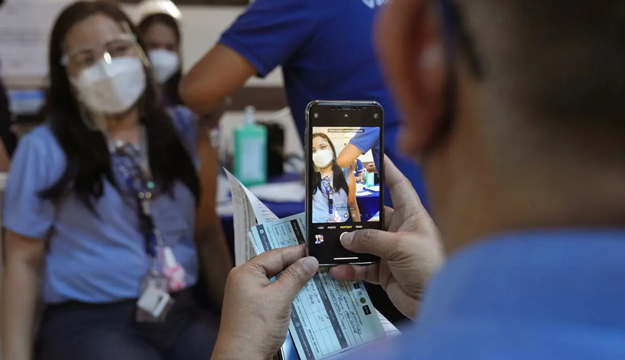 Seorang petugas kesehatan berpose untuk disuntik dengan vaksin COVID-19 Pfizer di National Kidney and Transplant Institute, Quezon City, Filipina, 17 November 2021. Pemerintah Filipina mulai menyuntikkan booster vaksin COVID-19 kepada pekerja garis depan. (AP Photo/Aaron Favila)