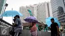 Sejumlah warga menggunakan payung saat menghadiri Car Free Day di Bundaran HI, Jakarta, Minggu (13/11). Meski gerimis di kawasan tersebut mereka tak surut untuk berolahraga. (Liputan6.com/Faizal Fanani)