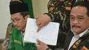 Wakil Ketum GP Ansor Benny Rhamdani menunjukkan tulisan yang berbunyi "ha ti ha ti man haj ba til" dari buku pelajaran tingkat TK yang isinya memuat unsur radikalisme saat jumpa pers di Kantor GP Ansor, Jakarta, Rabu (20/1). (Liputan6.com/Faizal Fanani)