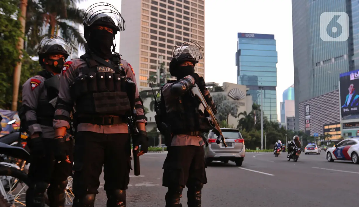Aparat kepolisian bersenjata lengkap bersiaga di kawasan Bundaran Hotel Indonesia (HI),  Jakarta, Rabu (12/5/2021). Pengamanan ketat tersebut dilakukan untuk menjaga perayan Idul Fitri 1442 di jantung Ibu Kota. (Liputan6.com/Angga Yuniar)