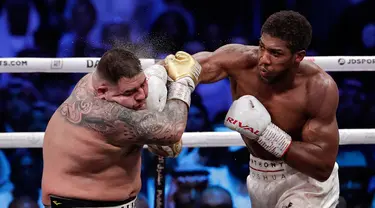 Petinju Anthony Joshua (kanan) melakukan pukulan ke wajah Andy Ruiz Jr (kiri) dalam pertandingan kejuaraan tinju kelas berat dunia di Diriyah Arena, Riyadh, Arab Saudi, Minggu (8/12/2019). Anthony Joshua menang angka mutlak atas Andy Ruiz Jr. (AP Photo/Hassan Ammar)