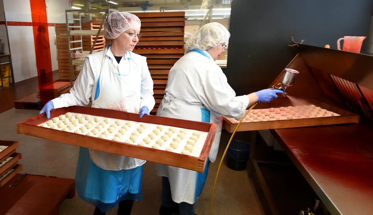 Pekerja memberi warna pada kue yang terbuat dari marzipan segar di tempat pembuatan tradisional JG Niederegger GmbH di Luebeck, Jerman (5/12). Marzipan adalah adonan yang bahan utamanya terbuat dari cacahan kacang almond dan gula. (AFP Photo/Stollarz)