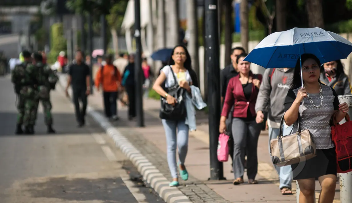 Sejumlah karyawan tampak kompak berjalan menelusuri trotoar untuk menuju kantornya di sekitar kawasan Bundaran HI, Jakarta, Rabu (22/4/2015). Sejumlah jalan utama di Jakarta ditutup untuk sementara waktu terkait puncak KAA. (Liputan6.com/Faizal Fanani)