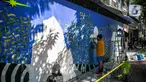 Seniman mural komunitas Converse All Stars melukis dinding Institut Perancis Indonesia (IFI) di Jalan MH. Thamrin, Jakarta, Rabu (2/12/2020). Dalam aksinya, seniman mural melukis dengan cat khusus ramah lingkungan yang diklaim bisa mengurangi polutan udara berbahaya. (Liputan6.com/Faizal Fanani)