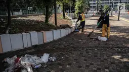 Petugas membersihkan sisa sampah bekas pertandingan Final Piala Presiden 2018 di area Stadion Utama Gelora Bung Karno, Jakarta, Senin (19/10). Sampah-sampah tersebut ditinggalkan para suporter Persija Jakarta dan Bali United. (Liputan6.com/Faizal Fanani)