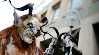 Sejumlah orang berkostum Krampuss selama parade di Munich, Jerman, Minggu (13/12). Dalam ceritanya Krampuss biasanya membawa cambuk hingga lonceng besar untuk menakut-nakuti anak-anak. (REUTERS/Michael Dalder)