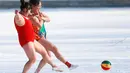 Dua orang wanita mengenakan pakaian renang menendang bola di lapangan bersalju di Shenyang, Provinsi Liaoning, Tiongkok (8/3). Mereka mengenakan pakaian renang bermain bola ketika peringatan Hari Perempuan Internasional. (AFP Photo/China Out)