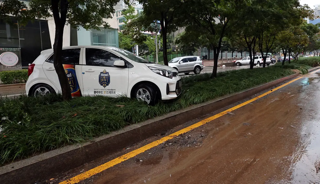 Sebuah mobil yang rusak akibat banjir terlihat di jalan setelah hujan deras di distrik Gangnam, Seoul pada Selasa (9/8/2022). Kali ini merupakan curah hujan terburuk dalam 80 tahun, menurut Administrasi Meteorologi Korea (KMA).  (YONHAP / AFP)