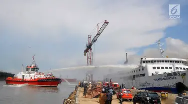 Pemadam kebakaran berusaha memadamkan api yang membakar kapal Panorama Nusantara di Pelabuhan Tanjung Mas, Semarang, Senin (18/2). Kebakaran terjadi di kawasan Galangan Janata Marina Indah (JMI). (Liputan6.com/Gholib)