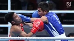 Petinju putra Indonesia, Sunan Agung Amoragam (kaus merah) mendapat pukulan Mirazizbek Mirzakhalilov (Uzbekistan) pada semifinal bantam 56kg putra Asian Games 2018 di JIEXPO Kemayoran, Jumat (31/8). Amoragam kalah 0-5. (Liputan6.com/Helmi Fithriansyah)