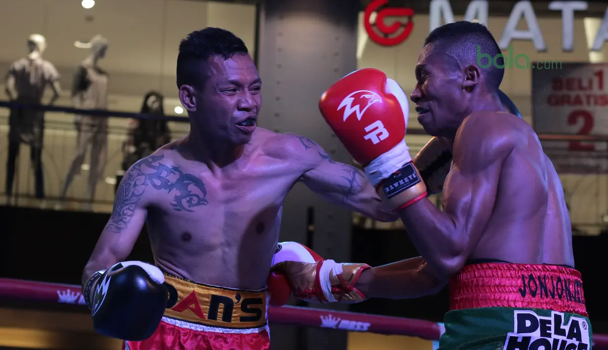 Frans Damur (kiri) melepaskan pukulan kearah Jon Jon Jet pada kelas Flyweight Mahkota Boxing Super Series di Cilandak Town Square, Jakarta (10/3/2018). Jon Jon Jetz menang angka mutalak atas Frans. (Bola.com/Nick Hanoatubun)