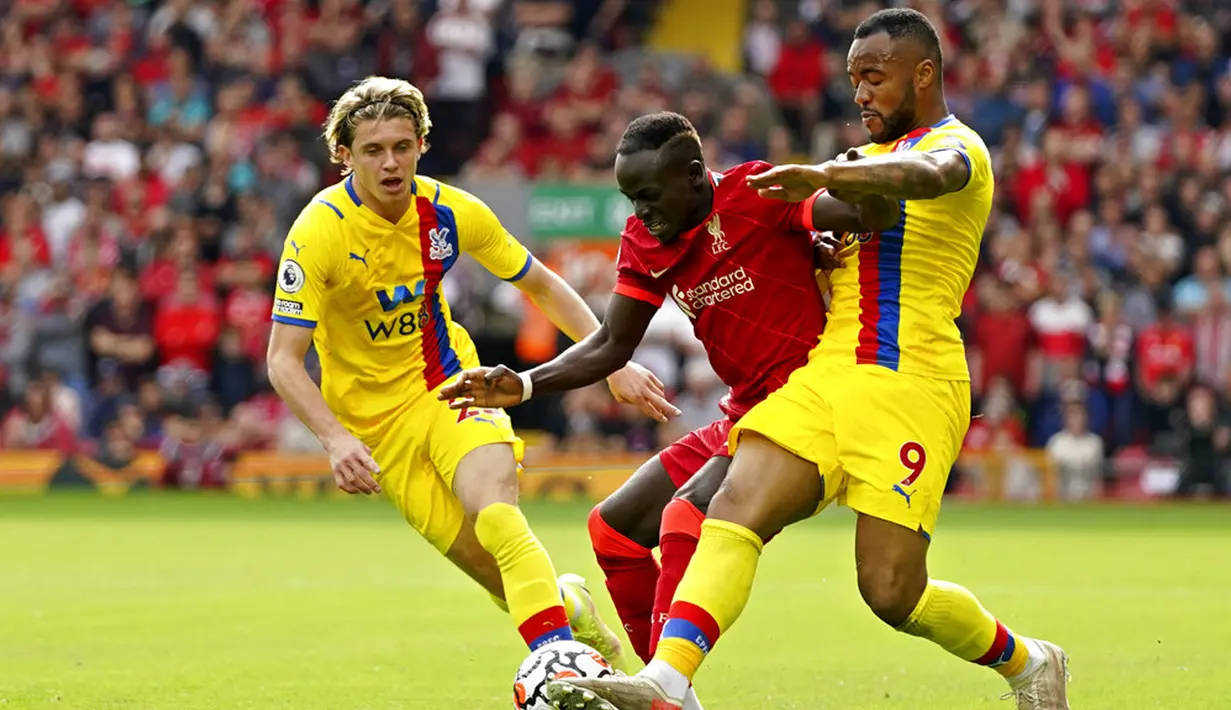 Pemain Liverpool Sadio Mane berebut bola dengan pemain Crystal Palace Jordan Ayew (kanan) pada pertandingan Liga Inggris di Stadion Anfield, Liverpool, Inggris, Sabtu (18/9/2021). Liverpool menang telak 3-0. (AP Photo/Jon Super)