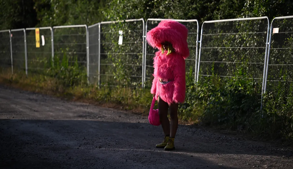 Seorang pengunjung festival berdiri di dekat pagar perimeter pada hari ke-2 festival Glastonbury di desa Pilton, Somerset, Inggris barat daya, pada tanggal 22 Juni 2023. Festival ini berlangsung dari tanggal 21 Juni hingga 26 Juni. (Photo by Oli SCARFF / AFP)