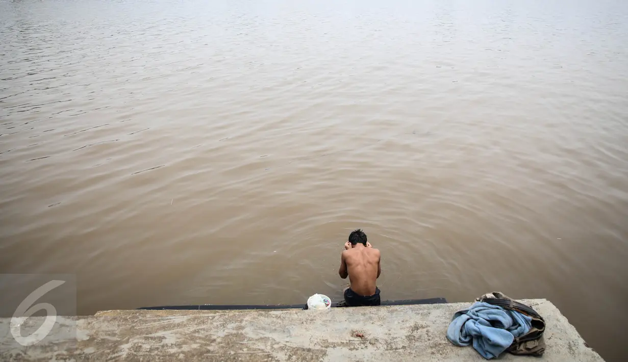 Seorang warga mandi di Sungai Kapuas, Pontianak, Kalimantan Barat, Minggu (23/8/2015). Kota Pontianak bakal disulap sejajar dengan kota kelas dunia melalui waterfront city (kota tepi sungai) di sepanjang Sungai Kapuas. (Liputan6.com/Faizal Fanani)