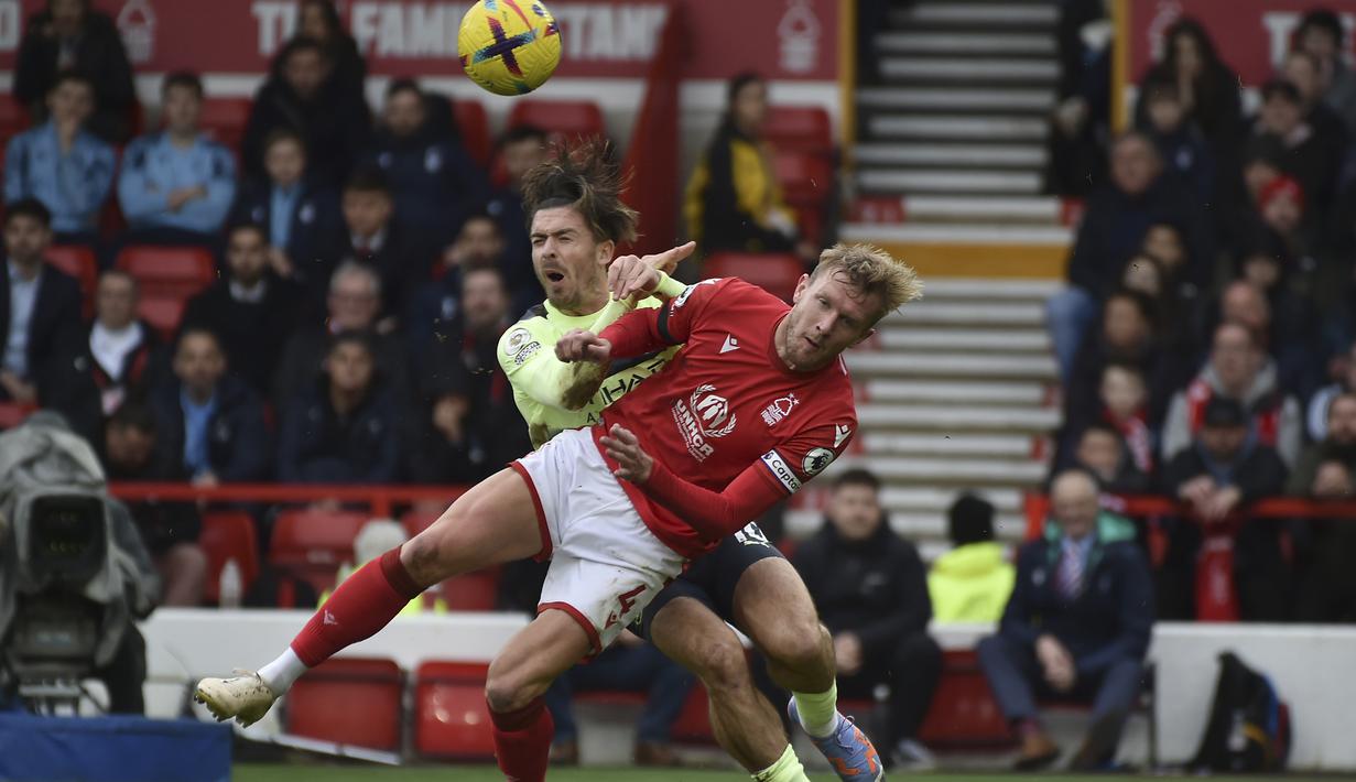 Gelandang Manchester City, Jack Grealish berebut bola dengan pemain Nottingham Forest, Joe Worrall selama pertandingan Liga Premier Inggris di  Stadion City Ground, Nottingham, Inggris, Sabtu (18/2/2023). Man City kini duduk di urutan kedua via catatan 52 angka, tertinggal dari Arsenal yang berada di puncak klasemen dengan 54 poin. (AP Photo/Rui Vieira)