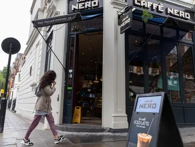 Seorang wanita melewati Caffe Nero yang dibuka kembali untuk layanan dibawa pulang (takeaway) di Maida Vale di London, Inggris (10/6/2020). Beberapa kedai kopi di Inggris telah dibuka kembali untuk pengiriman atau layanan takeaway dengan mengikuti aturan jaga jarak sosial. (Xinhua/Han Yan)