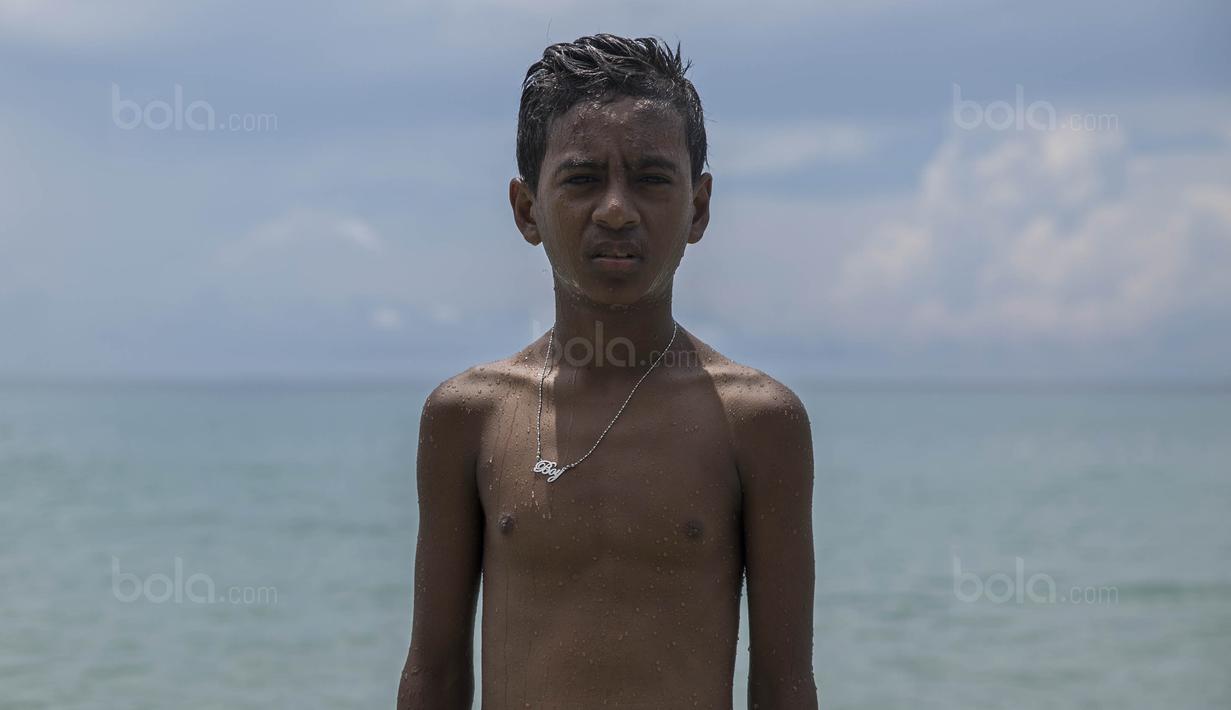 Pesepak bola SSB Tulehu Putra, Alghy Nahumarury, menendang bola usai latihan di tepi Pantai Tial, Maluku, Rabu (16/11/2017). Membahagiakan kedua orang tua menjadi harapan Alghy jika kelak bisa menjadi pemain profesional. (Bola.com/Vitalis Yogi Trisna)
