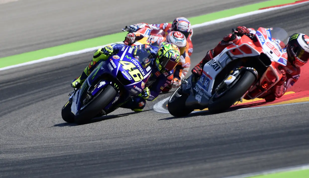Pembalap Movistar Yamaha, Valentino Rossi dan pembalap Ducati Team, Jorge Lorenzo memacu motor mereka pada balapan MotoGP Aragon di Spanyol, Minggu (24/9). Rossi comeback setelah satu seri absen akibat cedera kaki kanan. (JAVIER SORIANO/AFP)