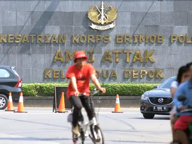 Warga melintasi jalan Komjen Pol M Yasin depan Mako Brimob Kelapa Dua, Depok, Kamis (10/5). Sebelumnya, terjadi kerusuhan di Rutan Salemba cabang Mako Brimob yang memakan korban lima orang petugas kepolisian. (Liputan6.com/Helmi Fithriansyah)
