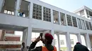 Para pekerja menyingkirkan pecahan kaca jendela setelah insiden kebakaran di luar bangsal Kesehatan Ibu dan Anak (MCH) di Rumah Sakit Pakistan Institute of Medical Sciences (PIMS), Islamabad, Pakistan, Rabu, 26 Agustus 2026. (AFP/  Aamir Qureshi)