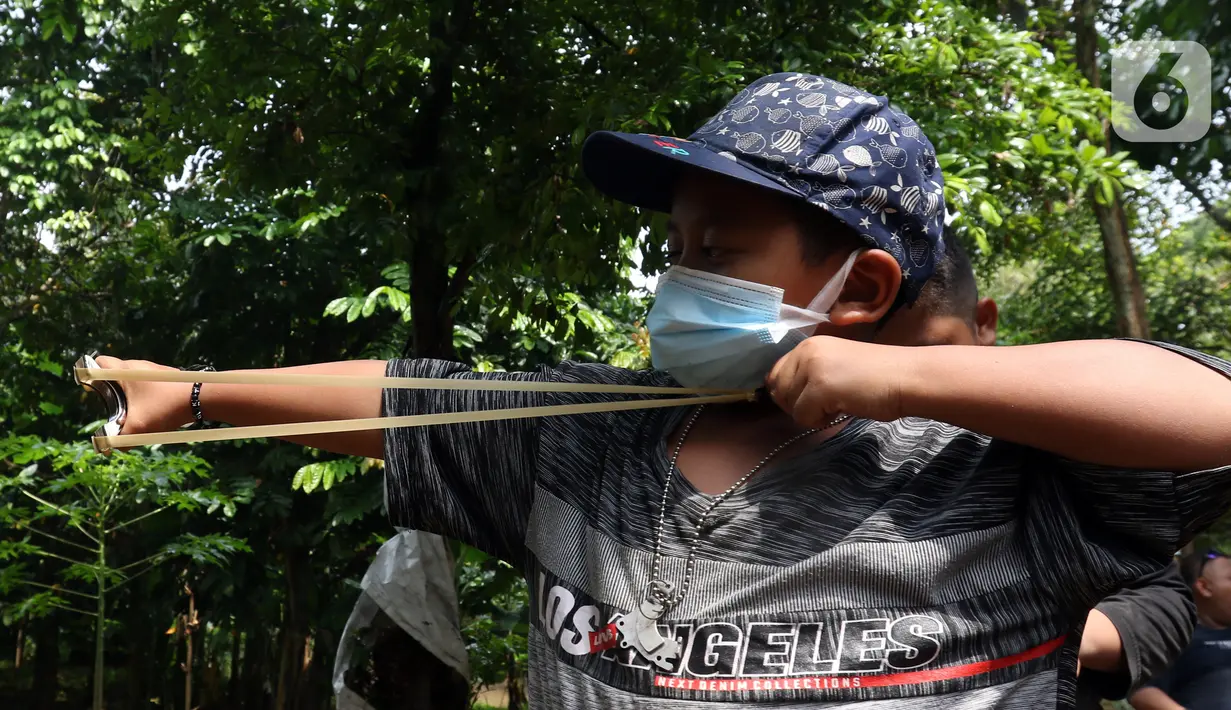 Anak-anak yang tergabung dalam Ketapel Anak Ciliwung (Kancil) bermain ketapel di kawasan Ciliwung Muara Baru, Jakarta, Selasa (9/11/2021). Selain melestarikan permainan tradisional, bermain ketapel dapat melatih kesabaran, konsentrasi dan motorik otak kanan bagi anak. (Liputan6.com/Herman Zakharia)