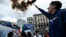Seorang fans Inter Milan menyalakan flare dan meneriakkan yel-yel di kawasan Piazza Duomo, Milan, Minggu (2/5/2021) merayakan kepastian Inter Milan merebut gelar juara Scudetto Liga Italia 2020/2021. (AFP/Piero Cruciati)