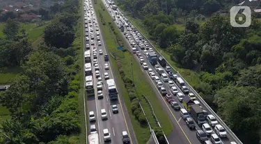 Foto udara memperlihatkan antrean kendaraan pemudik yang mengurangi laju kendaraannya saat melintasi jalan tol Palimanan-Kanci (Palikanci) KM 192, Cirebon, Jawa Barat, Minggu (7/4/2024). (Liputan6.com/Herman Zakharia)