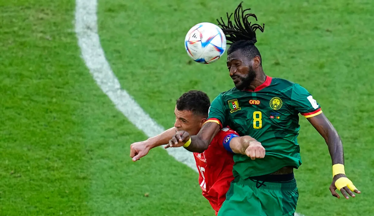<p>Pemain Swiss Granit Xhaka melompat untuk berebut bola udara dengan pemain Kamerun Andre-Frank Zambo Anguissa (kanan) pada pertandingan sepak bola Grup G Piala Dunia 2022 di Stadion Al Janoub, Al Wakrah, Qatar, Kamis (24/11/2022). Swiss mengalahkan Kamerun dengan skor 1-0. (AP Photo/Ebrahim Noroozi)</p>