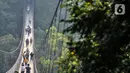 Pengunjung melintasi Jembatan Gantung Situ Gunung di Sukabumi, Minggu (20/9/2020). Seperti diketahui, Jembatan Gantung tersebut resmi dibuka untuk umum pada 2018 lalu itu memiliki panjang 243 meter dengan lebar 1,2 meter dan berada di atas ketinggian 107 meter. (merdeka.com/Iqbal S. Nugroho)