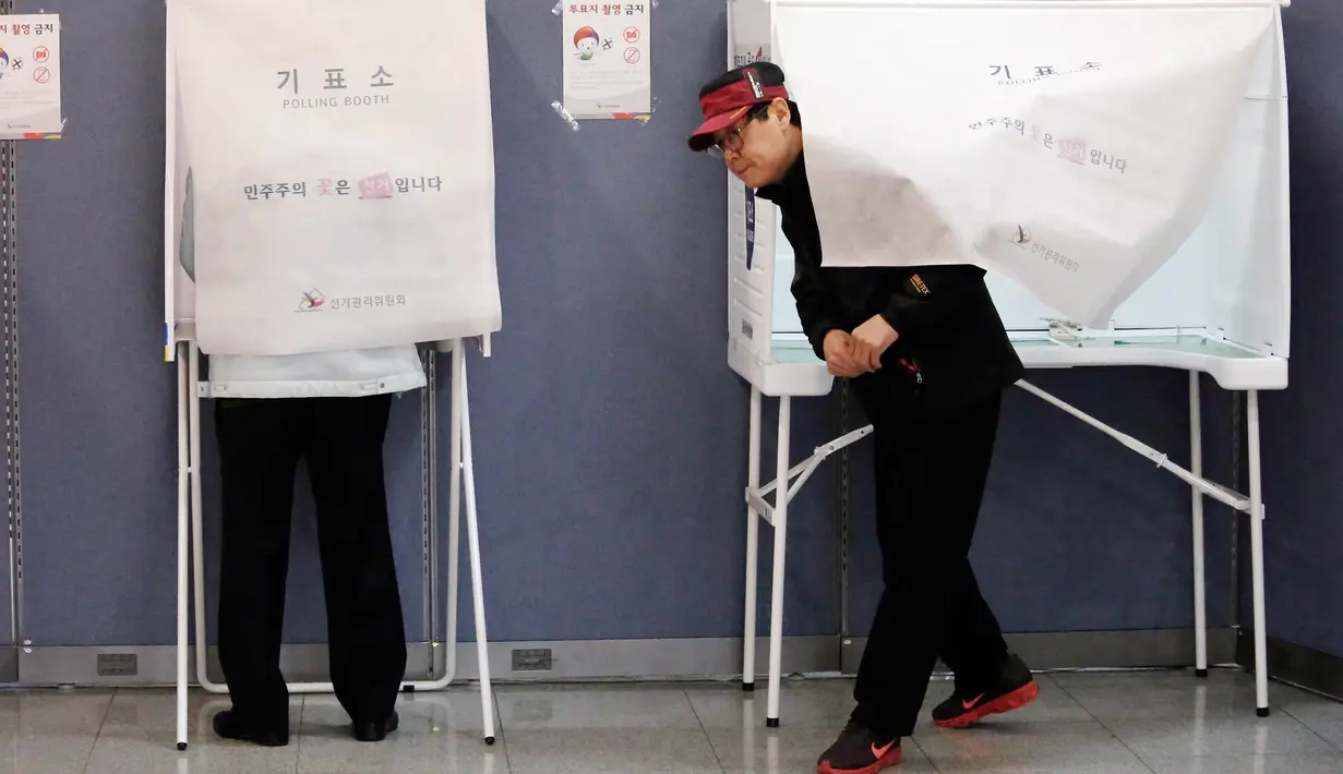 Seorang pria keluar dari bilik suara di sebuah TPS di Seoul, Selasa (9/5). Warga Korea Selatan (Korsel) menggunakan hak suaranya untuk memilih presiden baru setelah pemakzulan Park Geun-hye yang dijerat skandal korupsi. (AP Photo/Ahn Young-joon)